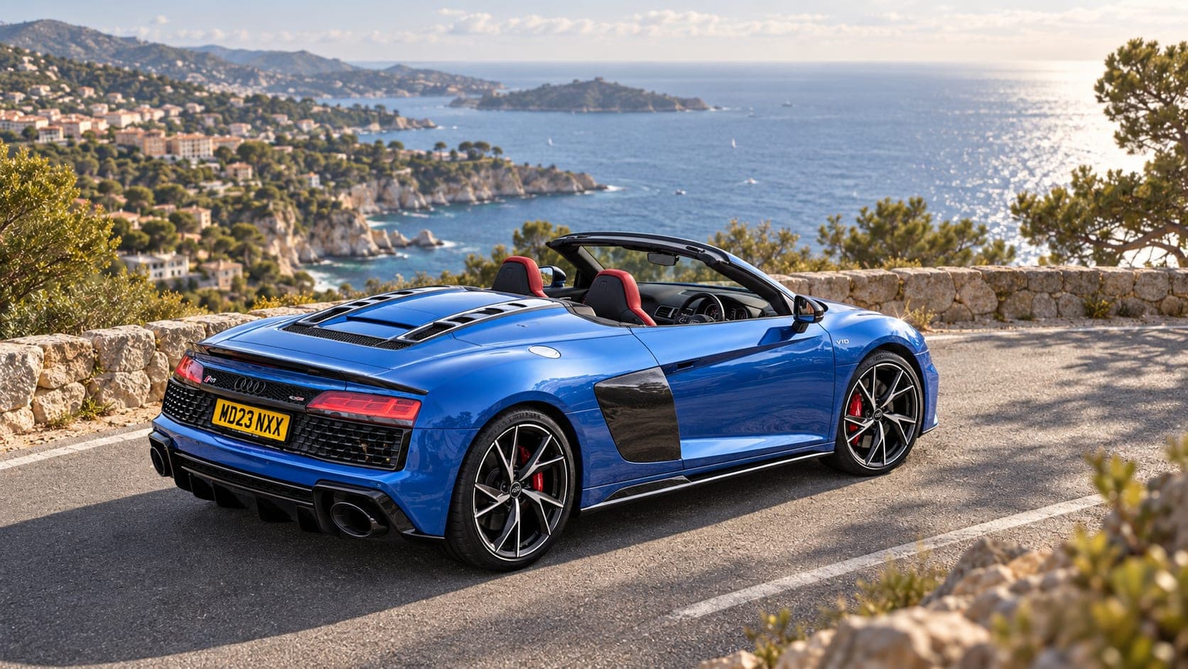 Blue Audi R8 Spyder V10 on a coastal road, rear three-quarter, available to hire from CVS Car Hire