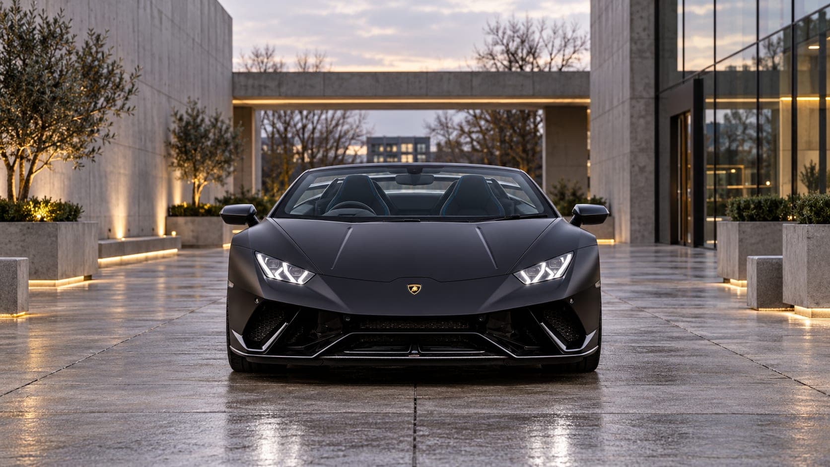 Matte black Lamborghini Huracán Performante Spyder head-on in a contemporary courtyard, available to hire from CVS Car Hire
