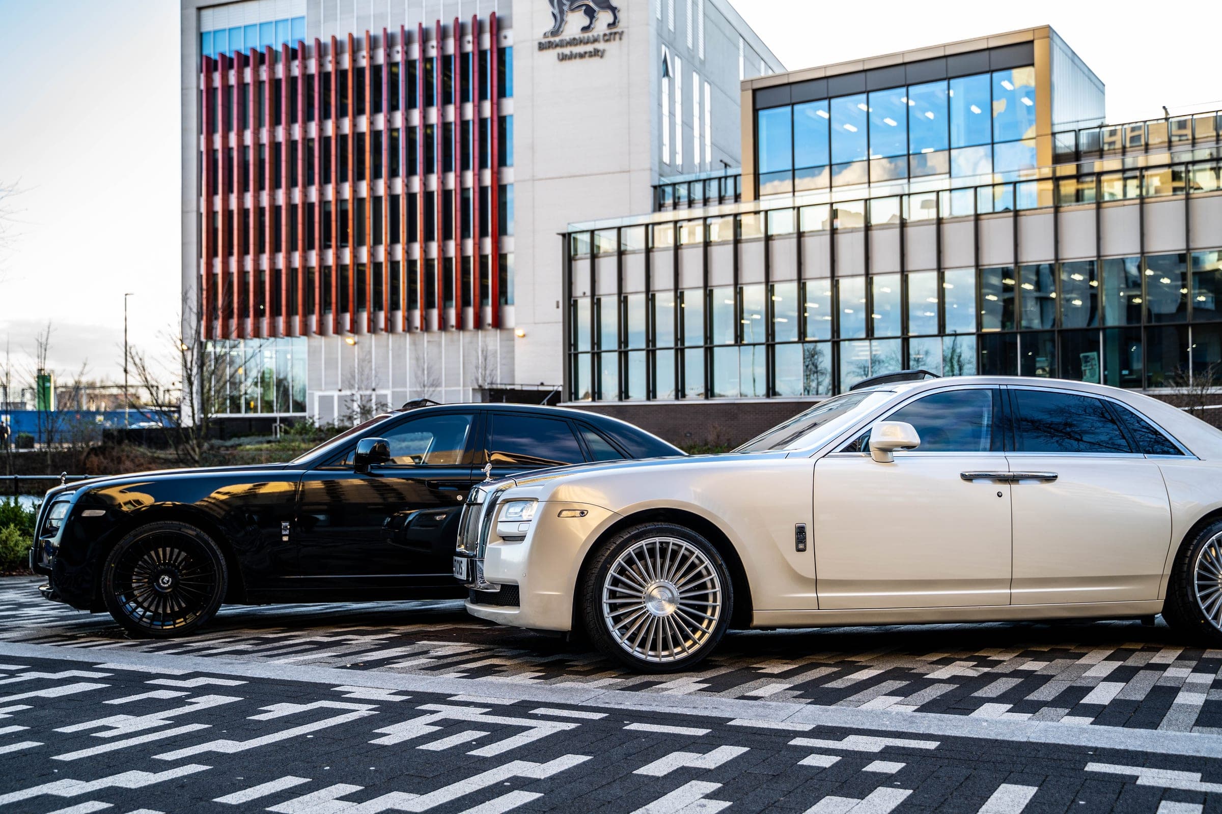 A pair of Rolls-Royce Ghosts in black and champagne